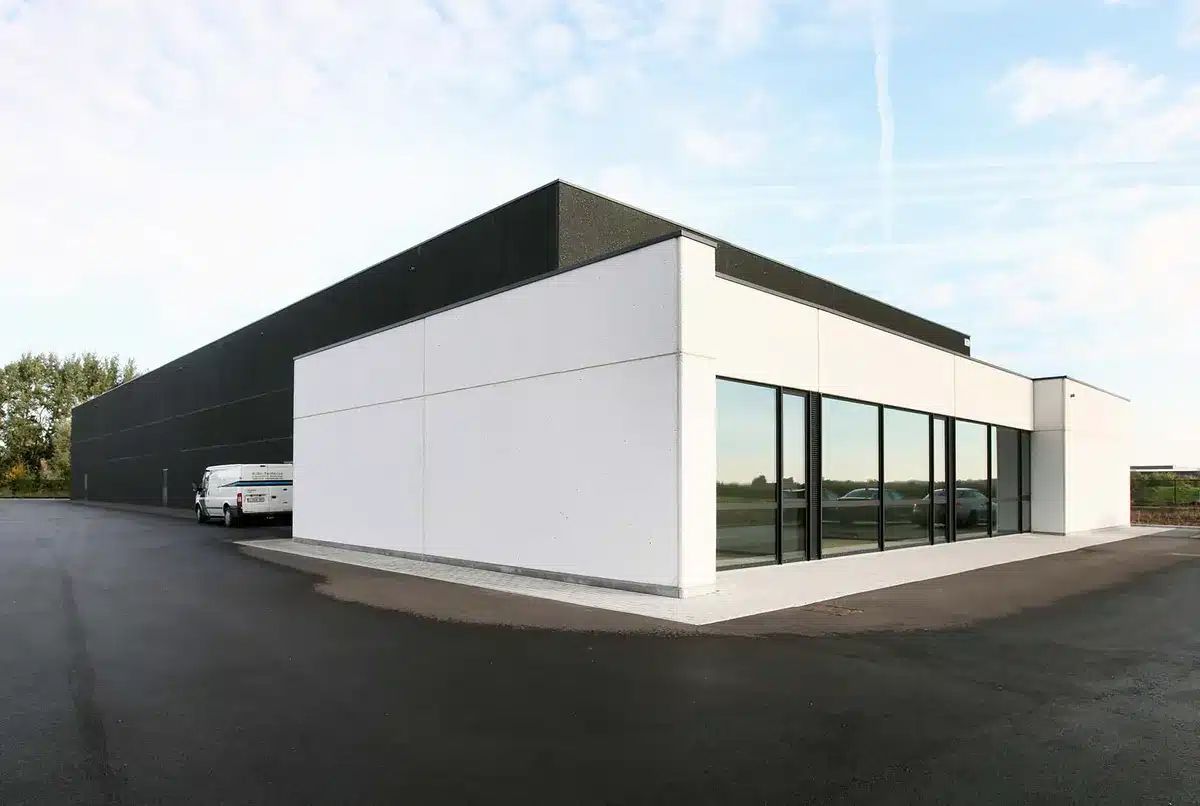 Bâtiment professionnel en béton préfabriqué : bureaux vitrés et entrepôt en béton noir